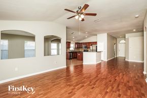 Land O Lakes house for rent - A spacious living room with a wood floor and a ceiling fan.