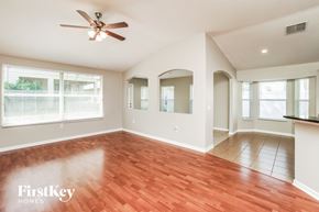 Land O Lakes house for rent - A spacious room with a ceiling fan and wooden flooring.