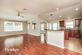 Land O Lakes house for rent - A spacious kitchen and living room with wood flooring and a ceiling fan.
