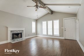 Helena house for rent - A spacious room with a fireplace and a ceiling fan.