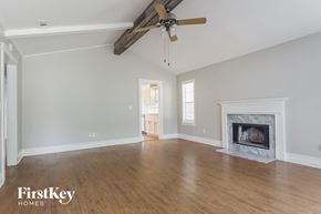 Helena house for rent - A spacious living room with a fireplace and a ceiling fan.