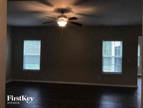 Gastonia house for rent - a living room with a ceiling fan and two windows