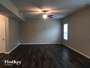 Gastonia house for rent - a empty living room with a ceiling fan and wood floors