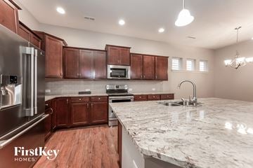 Indianapolis house for rent - A kitchen with wooden cabinets and a marble countertop.
