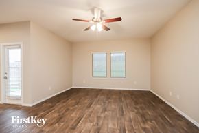 Conroe house for rent - A room with wooden floors and a ceiling fan.