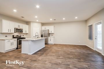 Conroe house for rent - A kitchen with white cabinets and a wooden floor.