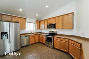 Tucson house for rent - a kitchen with wooden cabinets and stainless steel appliances