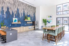 Oxnard apartment for rent - A modern kitchen with a blue tiled backsplash and wooden furniture.