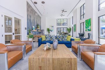 Oxnard apartment for rent - A modern living room with a wooden coffee table and orange leather chairs.