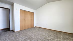 Fargo townhouse for rent - a bedroom with carpet and a door to a closet