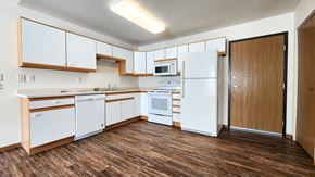 Fargo townhouse for rent - an empty kitchen with white appliances and wood floors