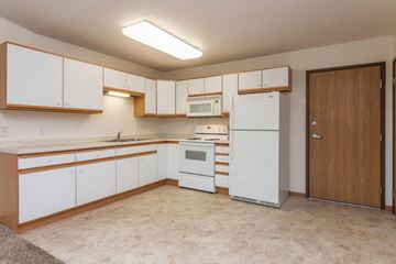 West Fargo apartment for rent - an empty kitchen with white appliances and white cabinets