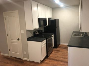St. Louis apartment for rent - a kitchen with white cabinets and a stove and a refrigerator
