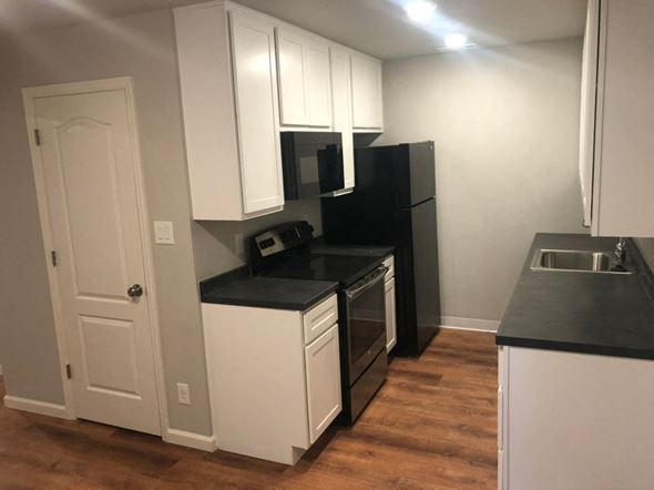 St. Louis apartment for rent - a kitchen with white cabinets and a stove and a refrigerator