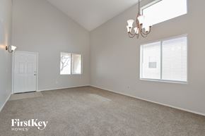 Vail house for rent - A spacious room with a carpeted floor, a chandelier, and two windows with blinds.