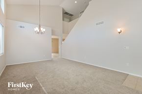 Vail house for rent - A spacious room with a carpeted floor and a chandelier hanging from the ceiling.
