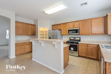 Vail house for rent - A kitchen with wooden cabinets and a white island.