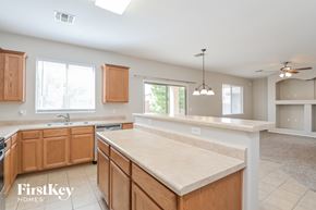 Vail house for rent - A kitchen with wooden cabinets and a marble countertop.