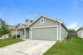 San Antonio house for rent - a blue house with a driveway and a green garage door