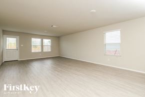 San Antonio house for rent - A spacious room with light wood flooring and a white door.