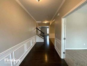 Cumming house for rent - A long hallway with a staircase on the left and a door on the right.