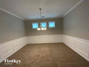 Cumming house for rent - A room with a carpeted floor and a chandelier hanging from the ceiling.