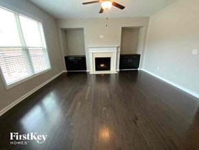 Cumming house for rent - A room with a fireplace and wood flooring.