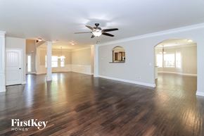 Hiram house for rent - A spacious room with wooden floors and a ceiling fan.