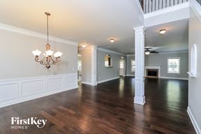 Hiram house for rent - A large, empty room with wooden floors and a chandelier.