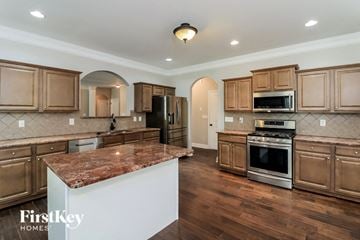 Hiram house for rent - A kitchen with wooden cabinets and a marble countertop.