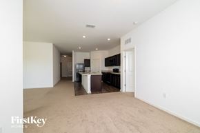 Haines City house for rent - A spacious living room with a kitchen in the background.