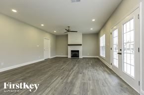Clarksville house for rent - A spacious room with a fireplace and a ceiling fan.