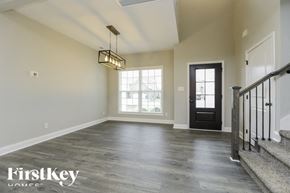 Clarksville house for rent - A spacious room with a wooden floor and a staircase on the right side.