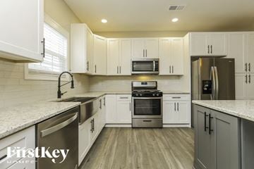Clarksville house for rent - A kitchen with white cabinets and stainless steel appliances.