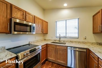 Tucson house for rent - a kitchen with wooden cabinets and stainless steel appliances