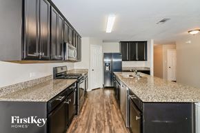 Hockley house for rent - A kitchen with black cabinets and granite countertops.