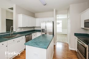 Matthews house for rent - a kitchen with white cabinets and green counter tops