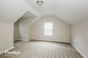 Matthews house for rent - a spacious attic room with carpet and a window