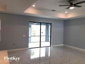 Lehigh Acres house for rent - A room with a sliding glass door and a ceiling fan.