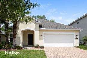 Jacksonville house for rent - A house with a white garage door and a palm tree in front.