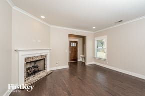 Birmingham house for rent - A spacious room with a fireplace and wooden floors.