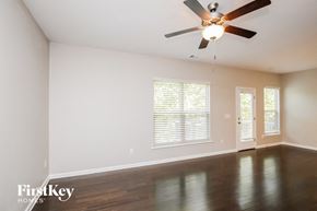 Lawrenceville house for rent - an empty living room with a ceiling fan and window