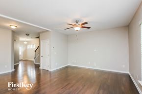 Lawrenceville house for rent - an empty living room with wood floors and a ceiling fan