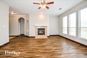 Rowlett house for rent - a living room with a fireplace and a ceiling fan