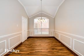 Rowlett house for rent - a dining room with wood floors and white walls and a window
