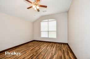 Rowlett house for rent - a bedroom with hardwood flooring and a ceiling fan