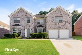 Stockbridge house for rent - a brick house with two garage doors and a lawn
