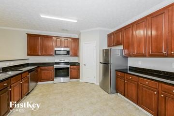 Stockbridge house for rent - a kitchen with wooden cabinets and stainless steel appliances