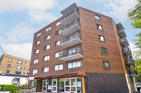 Montreal apartment for rent - A tall apartment building with balconies on the upper floors.