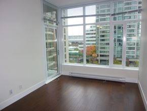 Vancouver apartment for rent - A room with a large window overlooking a cityscape.
